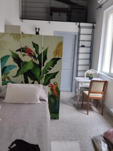 ein Schlafzimmer mit einem Bett mit einem Vogelbild an der Wand in der Unterkunft Lacasadilu in Neapel