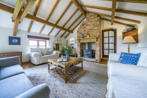 a living room with couches and a fireplace at The Old Piggeries in Burton Bradstock