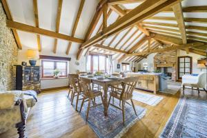 una cucina e un soggiorno con tavolo e sedie di The Old Piggeries a Burton Bradstock