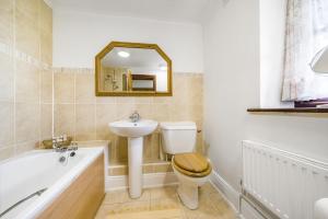 un bagno con un water, un lavandino e una vasca di The Old Piggeries a Burton Bradstock Altre 28 foto