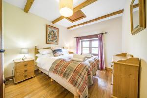 una camera da letto con un letto e una finestra di The Old Piggeries a Burton Bradstock