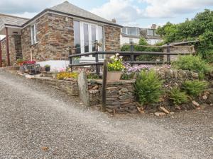 a garden in front of a house with flowers at Sunset Cottage in Tintagel