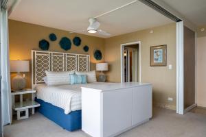 1 dormitorio con 1 cama grande y cabecero blanco en Oceanfront Mana Kai 2 bedroom condo en Wailea