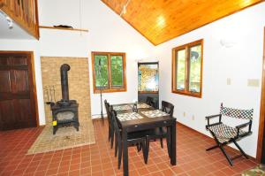 a room with a table and a wood stove at River Valley Cabin - Riverfront Cabin in Morton Grove