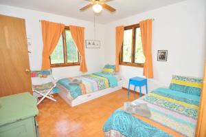 a bedroom with two beds and a chair and windows at River Valley Cabin - Riverfront Cabin in Morton Grove