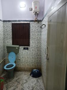 a bathroom with a green toilet and a window at Peaceful Living in Kolkata