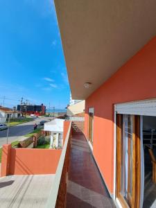 un balcón de un edificio con una pared de color naranja en Depa en Constitución en Mar del Plata
