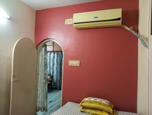 a room with a air conditioner on a red wall at Peaceful Living in Kolkata