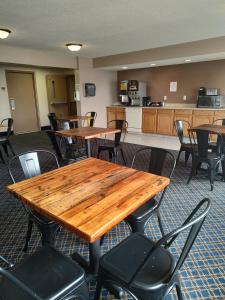 a room with tables and chairs and a kitchen at Rodeway Inn in Fargo