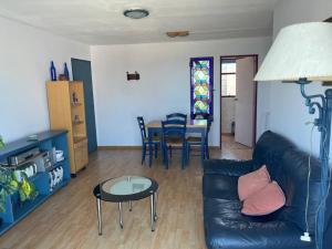 a living room with a black leather couch and a table at Apto próximo a casco histórico in Montevideo
