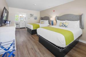 a hotel room with two beds and a television at Pelham on Earle in West Harwich