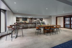 a large room with tables and bar stools at Courtyard Manchester-Boston Regional Airport in Manchester