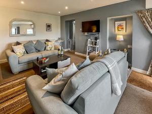 a living room with a couch and a table at Hyfrydle Cottage in Pen-y-groes