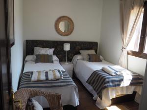 sypialnia z 2 łóżkami i lustrem w obiekcie El Cañuelo de Casa Román w mieście El Castillo de las Guardas