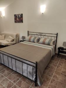 una camera con un grande letto e un divano di IL GIARDINO DI TITA - Salento a Maglie