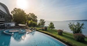 a large swimming pool next to a large body of water at Villa Melanie in Überlingen