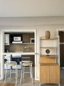 a kitchen with two stools and a table and chairs at Rent a Flat in Cordoba