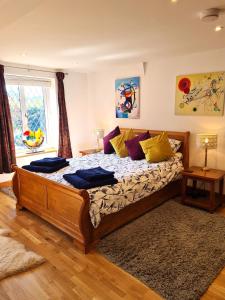 a bedroom with a large wooden bed with yellow pillows at Topsy-Turvy, Gardeners Cottage, Clungunford, Ludlow, Shropshire SY70PN in Broome