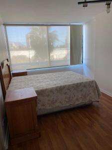 - une chambre avec un lit et une grande fenêtre dans l'établissement Departamento Playa Cavancha Arriendo mínimo tres noches, à Iquique
