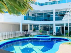 a swimming pool in front of a building at Hotel Abi Inn By GEH Suites in Cartagena de Indias