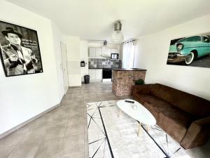 un soggiorno con un divano e un tavolo di T2 climatisé au cœur du pôle Aéronautique,à 8 minutes de l'aéroport a Colomiers Altre 5 foto