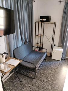Habitación con cama, escritorio y TV. en Staying in Athens, en Atenas