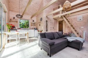 a living room with a couch and a kitchen at Letnisko Lubiatowo in Lubiatowo