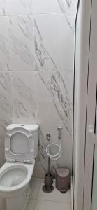 PIMONTAPARTMENTS في سبارجوس: مرحاض أبيض في حمام بجدران من الرخام
