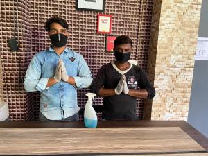 two men with masks on their faces at a table at The Velvet Chinhat Tiraha in Chinhat