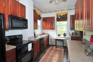 a kitchen with wooden cabinets and a black appliances at Manor at Berkeley Springs in Berkeley Springs