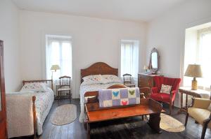 a bedroom with a bed and a chair and a mirror at Manor at Berkeley Springs in Berkeley Springs