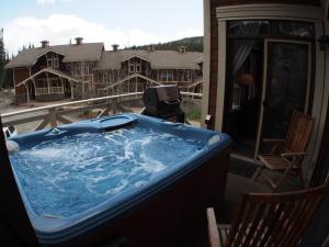 a hot tub on the balcony of a house at Stones Throw #38 By Bear Country in Sun Peaks