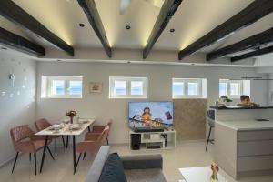 a living room with a tv and a table at Studio apartman Lenox in Rijeka