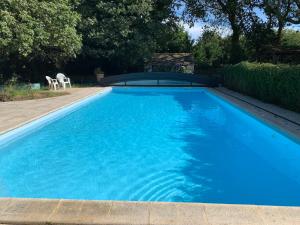 una gran piscina azul en un patio en La Gentilhommière, en Tréffiagat
