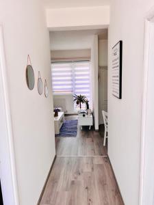 a hallway with a room with white walls and wooden floors at M Apartman in Foča +8 photos