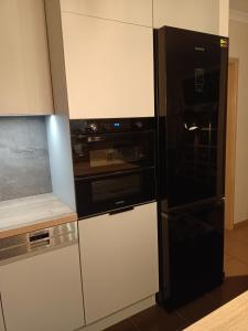 a kitchen with a black refrigerator and a black oven at Apartament Na Wydmie in Ustka