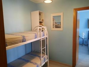 トッレ・グランデにあるAppartamento Azzurroの二段ベッド2台と廊下が備わる客室です。