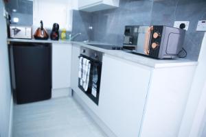 a kitchen with a microwave on top of a counter at Harrow Luxury flat With free parking. in London