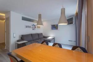 uma sala de estar com uma mesa e um sofá em Bright Lisbon T2 with 35 m2 Terrace, 2bed and 2bath and fast internet! em Lisboa