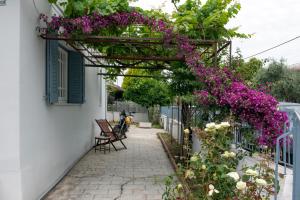 a pergola with purple flowers on a house at Met & Kas corner spacious house with countryard in Volos