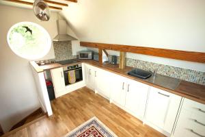 Broome的住宿－Topsy-Turvy, Gardeners Cottage, Clungunford, Ludlow, Shropshire SY70PN，享有厨房的顶部景致,厨房配有白色橱柜