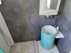 a bathroom with a blue trash can and a sink at Staying in Athens in Athens