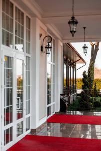 vestíbulo con alfombra roja y ventanas en Hotel Grand Aristocrate, en Dubovtsy