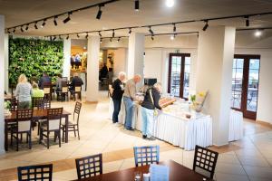 a group of people standing around a table in a room at Hotel Anek in Mrągowo