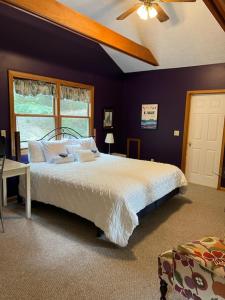 1 dormitorio con 1 cama grande y ventilador de techo en Healing House - Healing Escape, en Berkeley Springs
