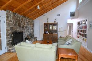 a living room with two couches and a stone fireplace at Home at Last - Gather here! in Berkeley Springs