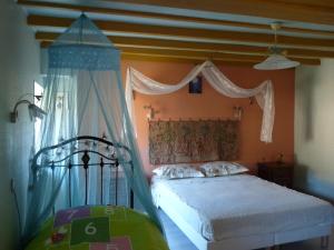 - une chambre avec un lit à baldaquin dans l'établissement Au val des meuris, à Taintrux