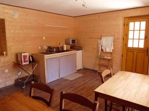 Cette chambre dispose d'une cuisine avec une table et un comptoir. dans l'établissement Au val des meuris, à Taintrux