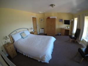 a bedroom with a bed and a desk and a chair at The Seaview Tavern in Ballygorman