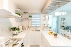 a white kitchen with a sink and a counter top at DGM AirBnB Urdaneta Pangasinan 